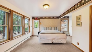 A bedroom with a bed, a window, and a door.