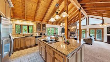 A spacious kitchen with granite countertops, wooden cabinets, and a large island.