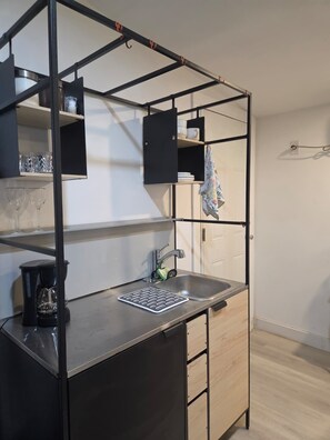 A compact kitchenette with a sink, coffee maker, and storage cabinets. - Cozy studio apartment in tranquil Cutler Bay with AC and parking available (Cutler Bay)