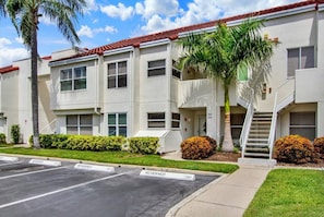 A multi-story residential building with a parking lot in front. - Isla Del Sol 2BR Coastal Paradise With Pool (St. Petersburg)