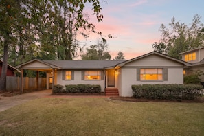A two-story house with a front porch, a covered entryway, and a well-maintained lawn. - Walk to Oxford Square | Sleeps 8 | Perfect for Ole Miss Getaways! (Oxford)