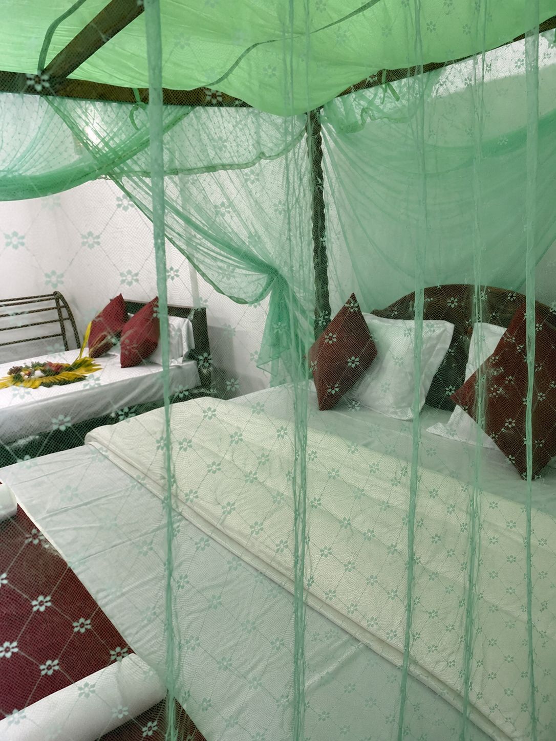 A bed with a canopy, pillows, and a bedside table with a lamp.