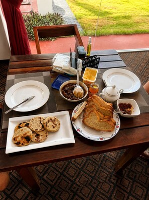 A table set with plates, bread, a teapot, and condiments.