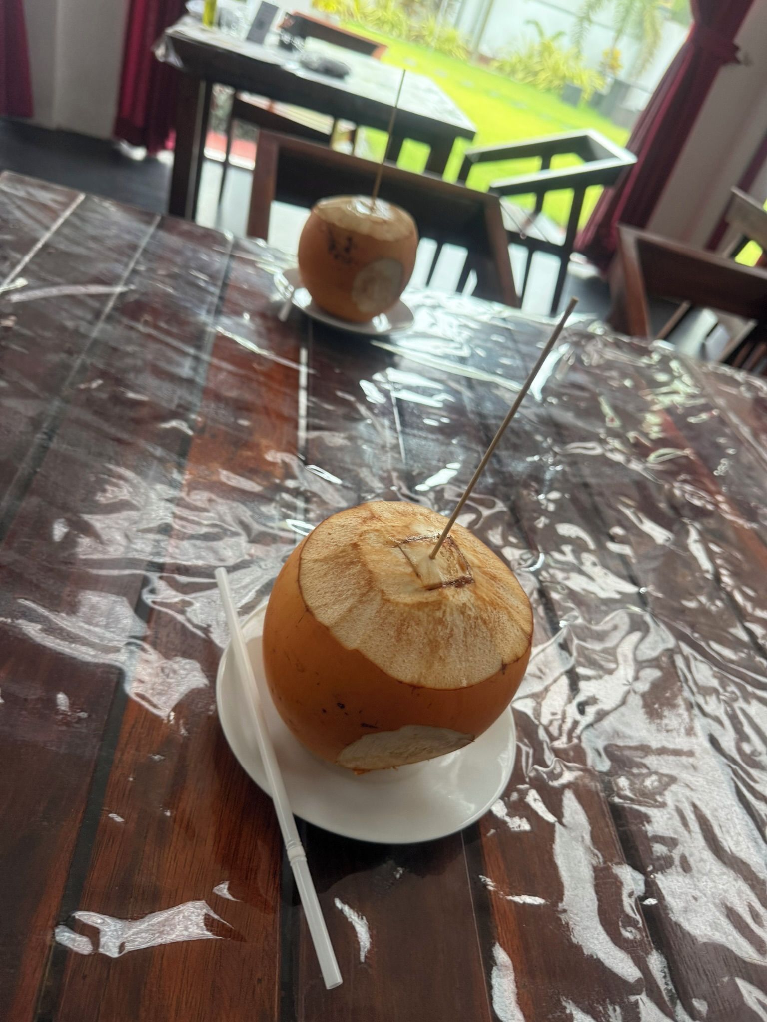 Ein Tisch mit einem Getränk im Glas, einem Strohhalm und einer Serviette.