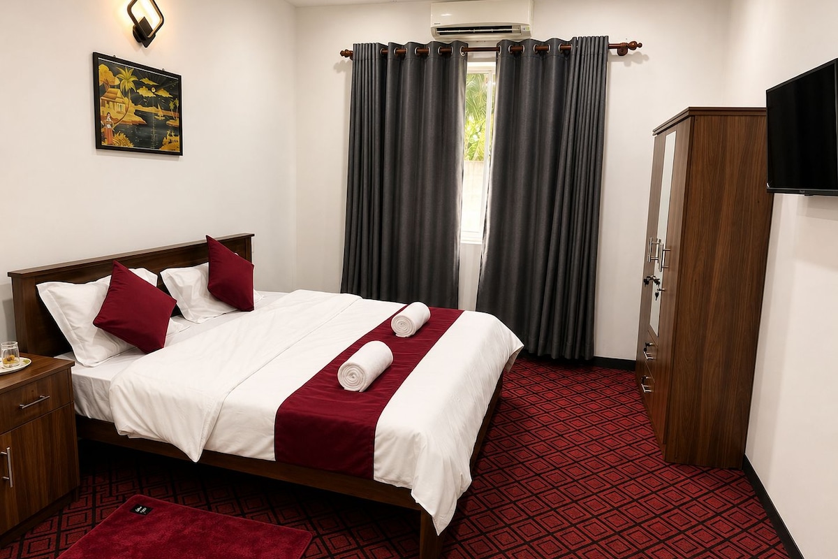 A hotel room with a bed, a wardrobe, a red carpet, a wall-mounted air conditioner, and a painting.