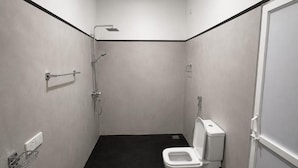 A small, enclosed bathroom with a toilet, a shower, and a sink. - Amore Beach Resort (Balapitiya)