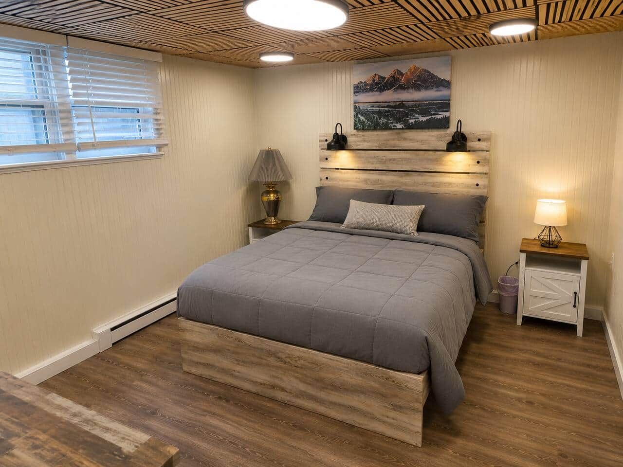 Ein Schlafzimmer mit einem Bett, Nachttischen, einer Lampe, einem Gemälde und Holzboden.