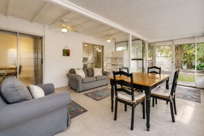 A spacious living area with a dining table, sofas, and a glass door leading to a garden. - Orlando Hub: Cozy Suburban Oasis / 25 Mins to Theme Parks  &Airport (Orlando)