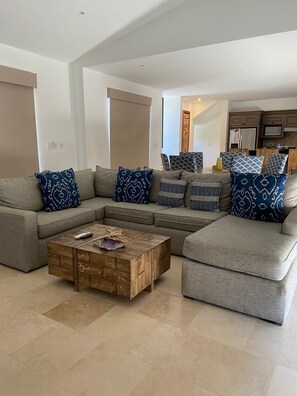 A modern living room with a sectional sofa, a wooden coffee table, and patterned cushions. - Charming 3-bedroom Modern Mexican house in a Exclusive Copala  Cabo San Lucas (Cabo San Lucas)