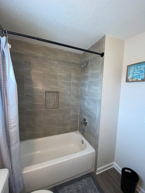 A bathroom with a bathtub, a shower, and a toilet.