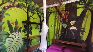 Quarto com cama, dossel suspenso e um mural de uma floresta.