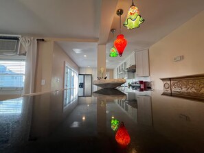 A modern kitchen with white cabinets, a stainless steel refrigerator, and a marble countertop. - Large 3BR/2BA - 1500sqf - Steps to Harvard (Cambridge)