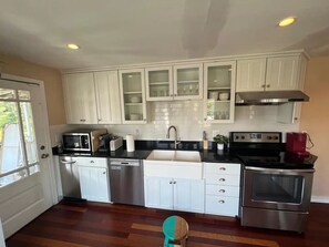 A kitchen with white cabinets, a stainless steel dishwasher, a microwave, a sink, a stove, and a toaster. - Large 3BR/2BA - 1500sqf - Steps to Harvard (Cambridge)