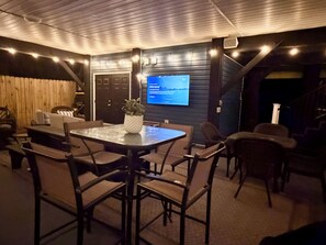 A cozy indoor seating area with a round table and chairs, a television mounted on the wall, and a staircase leading to another level. - Ocean Lakes 3 BR. Golf Cart & Linens. Outdoor Entertainment Area. 3 Min to Beach (Myrtle Beach)