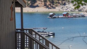 Un edificio in legno con un balcone che si affaccia su un lago tranquillo, con barche e pontili.