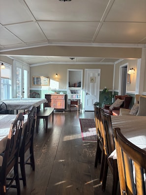 Een ruime kamer met een eethoek, een keuken en een zithoek.