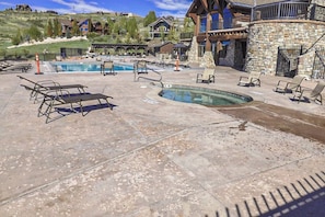 A pool area with lounge chairs and a stone building. - The Pirate Ship Chalet (Fish Haven)
