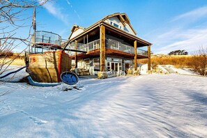 A two-story house with a balcony, a staircase, and a snow-covered driveway. - The Pirate Ship Chalet (Fish Haven)