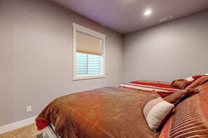 A bedroom with a bed, a window with blinds, and a ceiling light. - The Pirate Ship Chalet (Fish Haven)