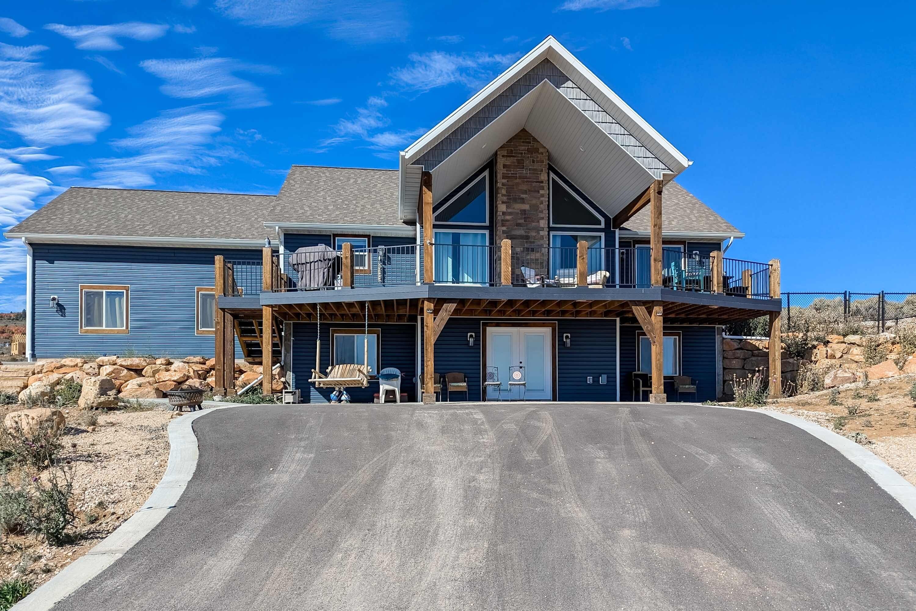A two-story house with a balcony, a garage, and a driveway.