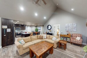 Ein geräumiges Wohnzimmer mit einem Ecksofa, einem Holztisch und einem Essbereich mit Tisch und Stühlen.