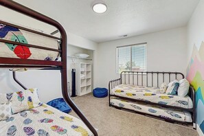 Ein Schlafsaalzimmer mit einem Fenster, einem Bücherregal und einem blauen Sitzsack.