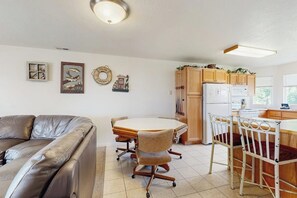 A kitchen with a dining table, chairs, and a refrigerator. - Tennis Court Condo - Lake Views, Pool & Hot Tub (Garden City)