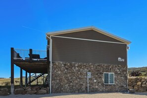 A two-story building with a stone facade and a balcony on the upper level. - Secluded Sunrise - Lake Views, Sleeps 23, Dogs OK (Garden City)