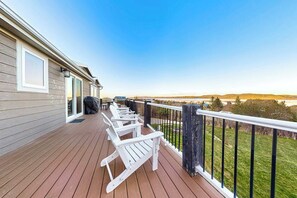 A deck with white Adirondack chairs, a grill, and a view of the landscape. - Secluded Sunrise - Lake Views, Sleeps 23, Dogs OK (Garden City)