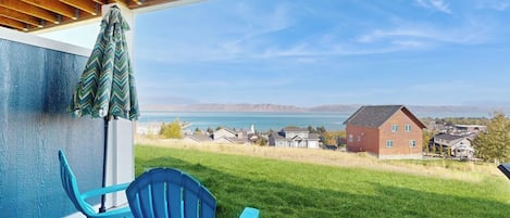 A covered outdoor area with a view of a lake and houses.