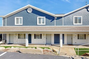 Een woonhuis met twee verdiepingen, een overdekte veranda, een garage en een verzorgd gazon.