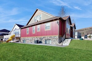 Un bâtiment rouge avec des fondations en pierre, un toboggan jaune et un ciel dégagé.