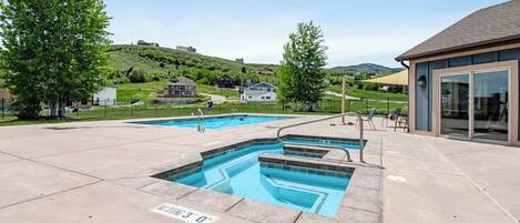 Una piscina con una vista despejada del paisaje circundante, incluyendo casas y una colina.