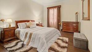 A bedroom with a bed, nightstands, a dresser, a mirror, and a window with curtains. - Holiday Home 'Vista Atlântica Garachico' with Sea View, Private Terrace & Wi-Fi (Câmara de Lobos)