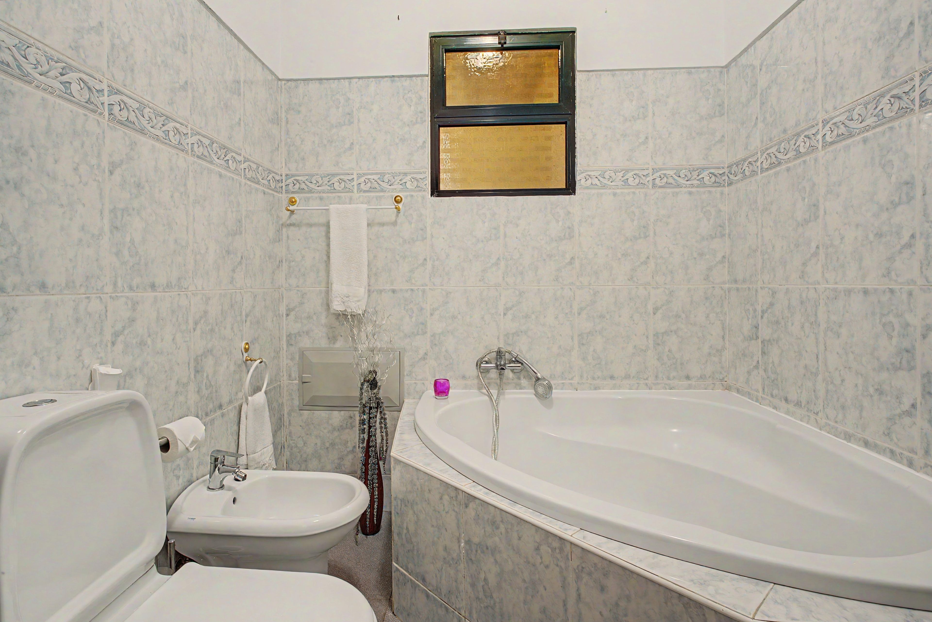 Une salle de bain avec une baignoire, des toilettes et un bidet.