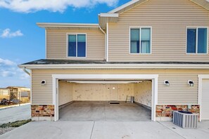 A two-story house with a garage entrance, stone accents, and a clear sky. - Bear Lake Memories - Pickleball & Mountain Views (Garden City)