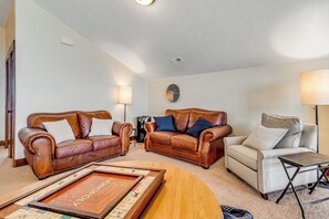 Ein Wohnzimmer mit zwei Ledersofas, einem Couchtisch und einer Lampe.