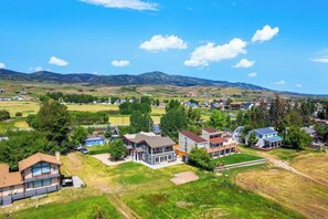 A residential area with houses, a clear sky, and a hilly landscape in the background. - Lakefront Retreat - Hot Tub, Game Room & Fire Pit (Garden City)