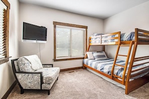A bedroom with a bunk bed, a sofa, a television, and a window with blinds. - Blue Bell - Lake Views, Pool, Hot Tub, Dogs OK (Garden City)