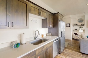 A modern kitchen with wooden cabinets, stainless steel appliances, and a built-in dishwasher. - Garden City Glee - Mountain Views, Dogs Welcome (Garden City)