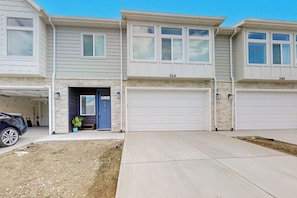 A residential building with two garages, a driveway, and a parked car. - Garden City Glee - Mountain Views, Dogs Welcome (Garden City)