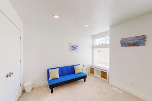 A room with a blue sofa, a small white table, a window with blinds, and a painting on the wall. - Garden City Glee - Mountain Views, Dogs Welcome (Garden City)