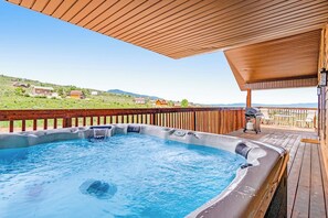 A hot tub on a wooden deck with a view of houses in the background. - Hilltop Hideaway - Lake Views, Hot Tub, Game Room (Garden City)