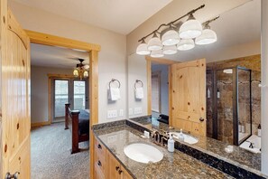 A bathroom with a large mirror, a sink, and a shower. - Hilltop Hideaway - Lake Views, Hot Tub, Game Room (Garden City)