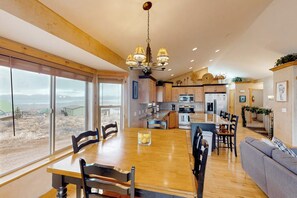 Un'ampia cucina con zona pranzo, grandi finestre e vista sull'esterno.
