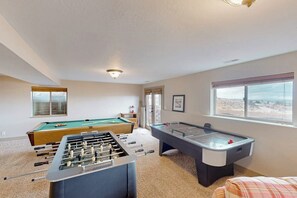 Ein Zimmer mit Kicker-, Billard- und Tischtennisplatten.