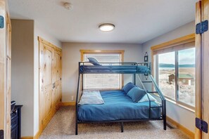 Camera con letto a castello e vista sul paesaggio attraverso una finestra.
