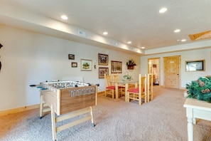 A room with a foosball table, a dining table with chairs, and a Christmas tree. - Marina View - Lake View Deck & Foosball (Garden City)