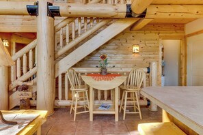 A wooden interior with a staircase, a table with chairs, and a welcome sign. - Marina View - Lake View Deck & Foosball (Garden City)