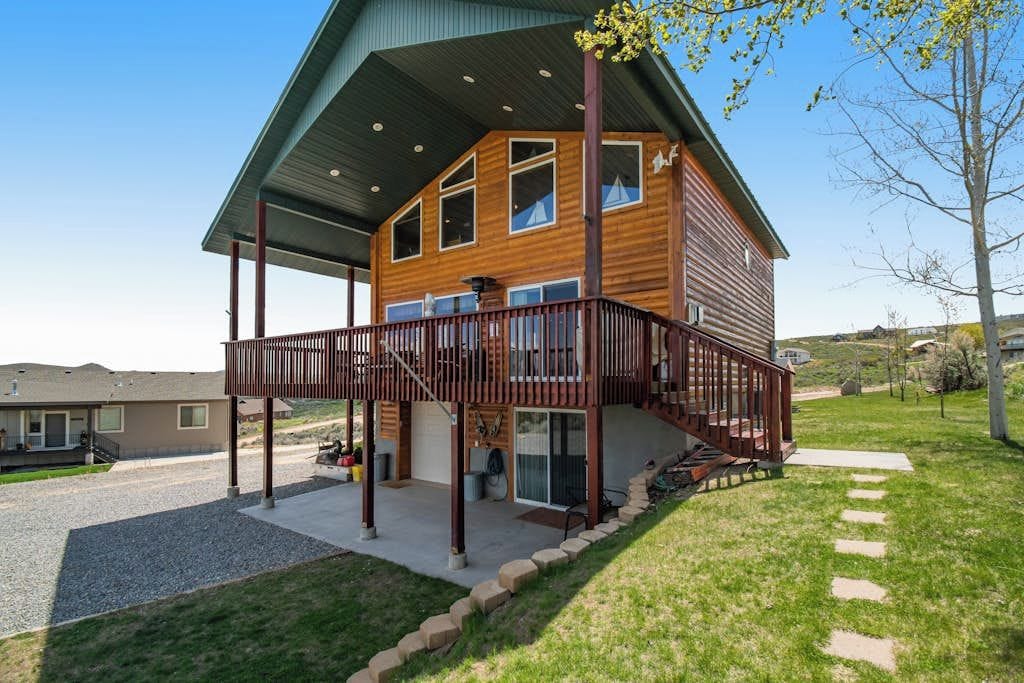 A two-story wooden house with a covered porch and a staircase leading to the upper level.
